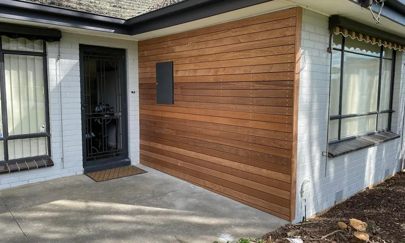 Timber clad wall on the front of a rendered home