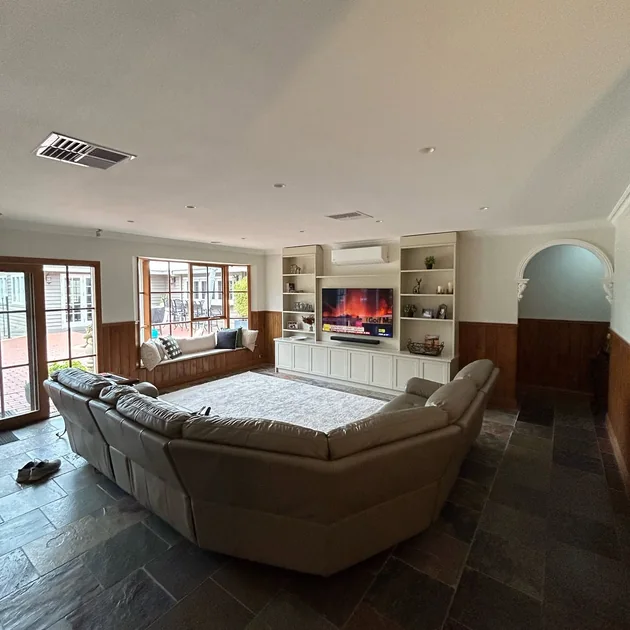 Renovated living area with a built-in fireplace and shelving