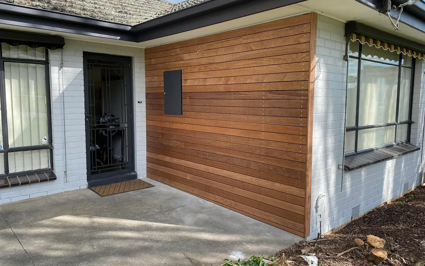Timber clad wall on the front of a rendered home