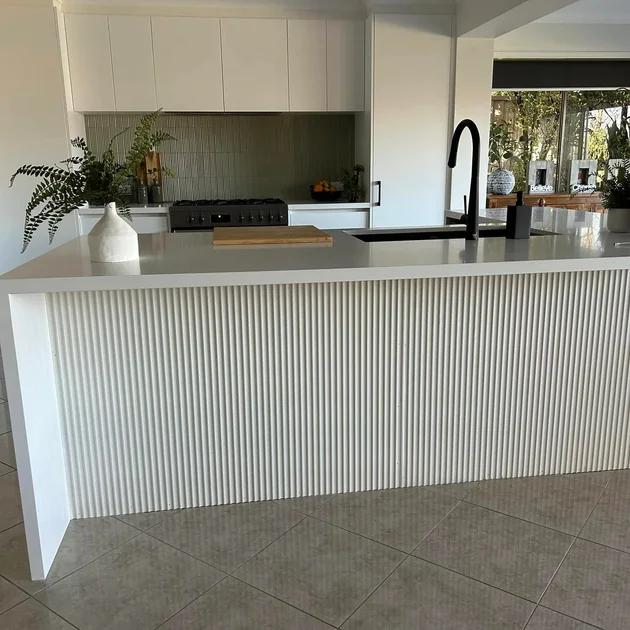 Renovated kitchen with a fluted island bench and stone top