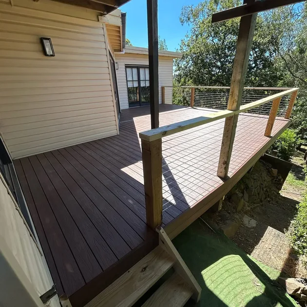 Composite deck with a cable balustrade and timber steps on a treed block