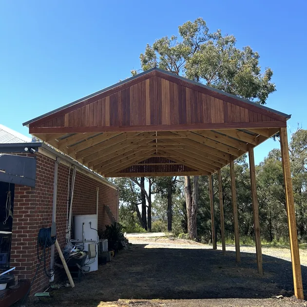 Gabled timber carport attached to the side of a brick home